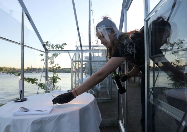 Официантка во время работы в ресторане в формате «карантинных теплиц» в Амстердаме - Sputnik Армения