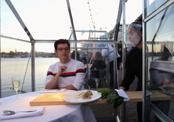 Официанты во время работы в ресторане в формате «карантинных теплиц» в Амстердаме - Sputnik Армения