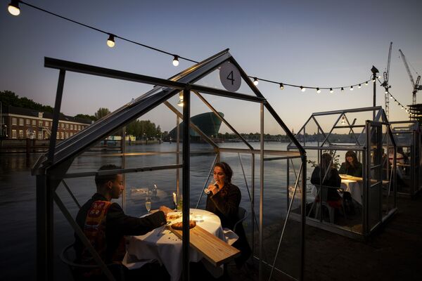Друзья во время обеда в ресторане в формате «карантинных теплиц» в Амстердаме - Sputnik Армения