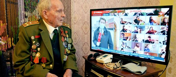 Ветеран Великой Отечественной войны Иван Иванович Довиденко смотрит онлайн-трансляцию акции Бессмертный полк (9 мая 2020). Челябинск - Sputnik Армения