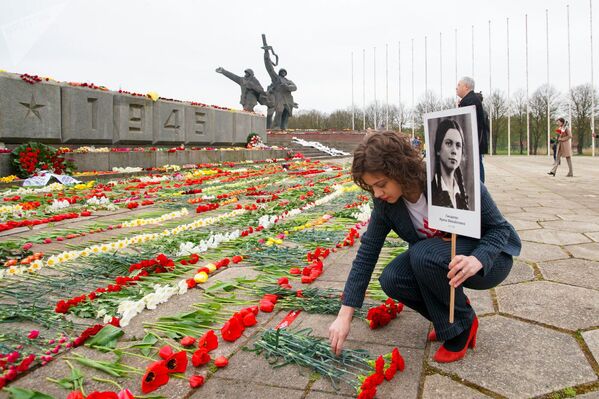 Организатор Бессмертного полка Маргарита Драгиле пришла к памятнику Освободителям с портретом бабушки-блокадницы (9 мая 2020). Латвия - Sputnik Армения