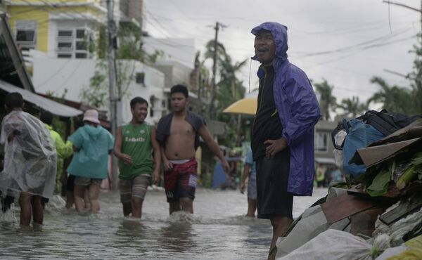 Местные жители на затопленной улице после тайфуна Вонфон, обрушившегося на центральную часть Филиппин. - Sputnik Армения