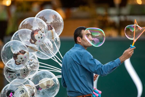 Продавец воздушных шаров привлекает внимание прохожих мыльными пузырями в центре столицы (22 мая 2020). Еревaн - Sputnik Армения