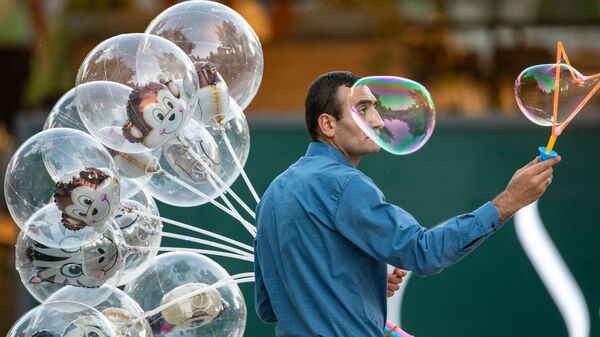 Продавец воздушных шаров привлекает внимание прохожих мыльными пузырями в центре столицы (22 мая 2020). Еревaн - Sputnik Արմենիա