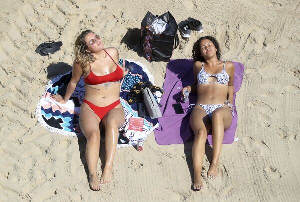 Две загорающие девушки на пляже Каллеркоатс, Англия  - Sputnik Армения