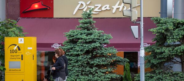 Женщины проходят мимо пиццерии Pizza Hut Женщины проходят мимо пиццерии Pizza Hut - Sputnik Армения