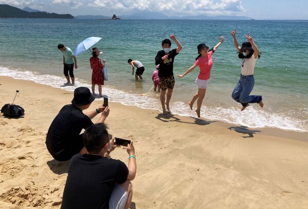 Люди в масках на пляже во время фотогарфирования в Китае  - Sputnik Армения