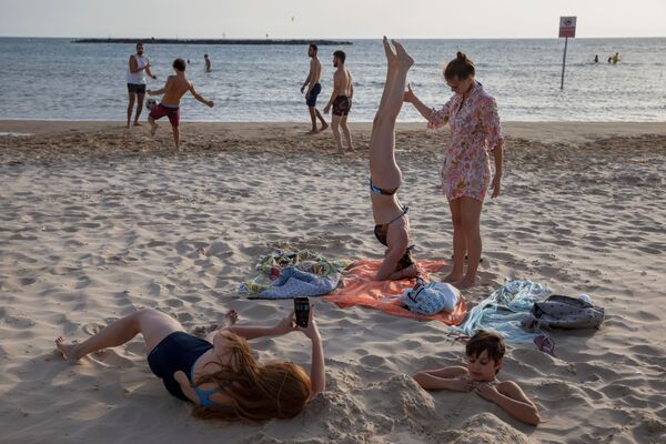 Люди во время отдыха на пляже в Тель-Авиве  - Sputnik Армения