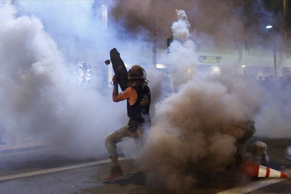 Протестующий прикрывается скейтбордом от слезоточивого газа во время демонстрации в связи со смертью Джорджа Флойда, убитого полицейским (29 мая 2020). Миннеаполис - Sputnik Армения