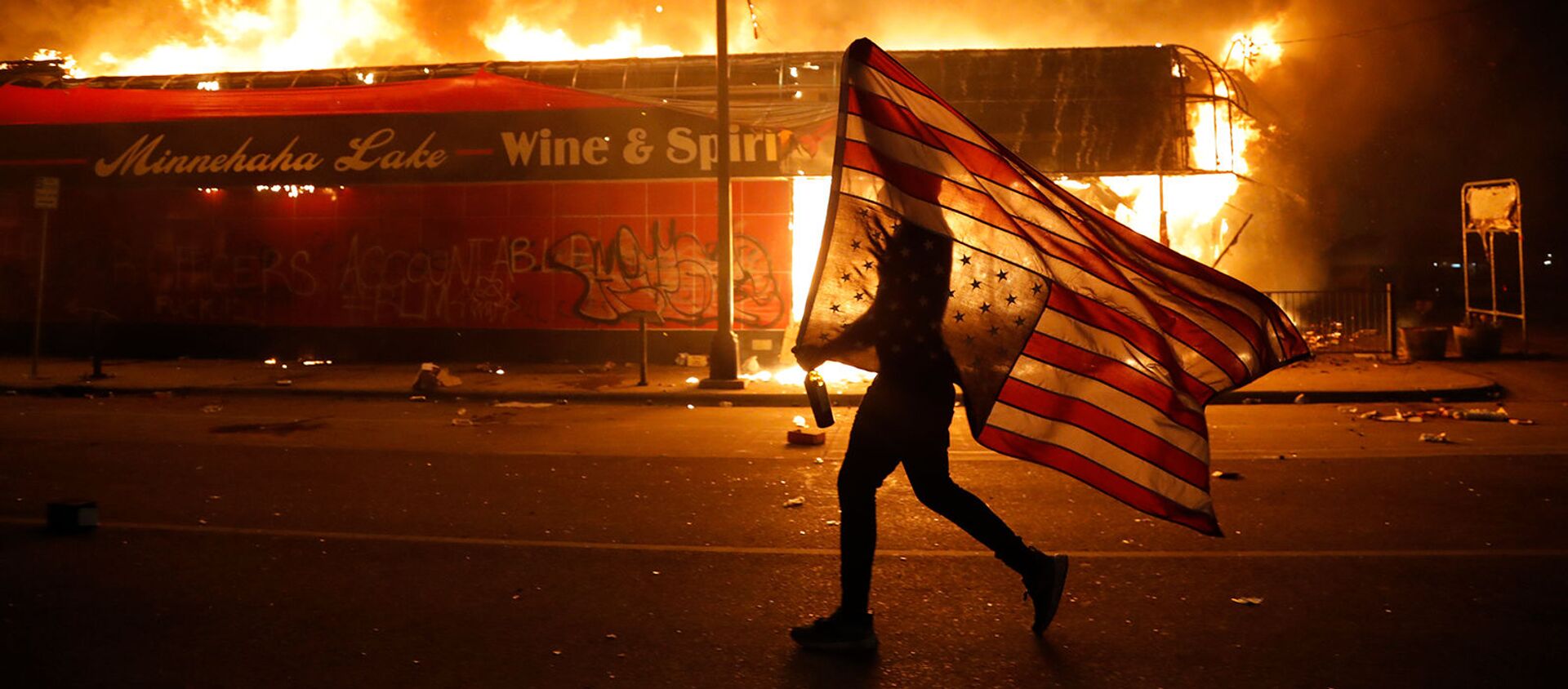 Протестующий с перевернутым флагом США во время демонстрации в связи со смертью Джорджа Флойда, убитого полицейским (28 мая 2020). Миннеаполис - Sputnik Армения, 1920, 02.06.2020