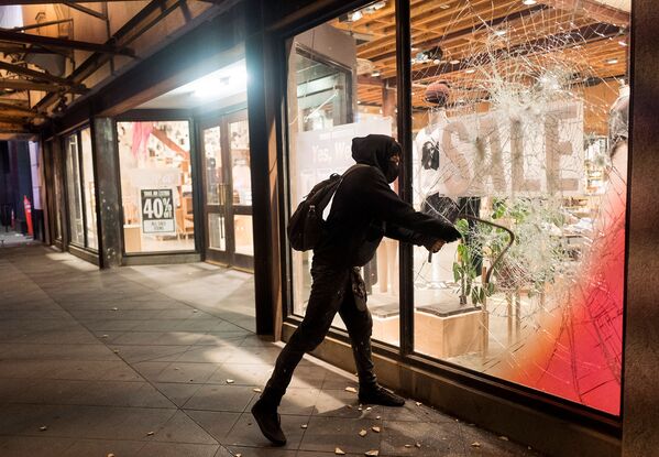 Протестующий разбивает витрину одного из предприятий во время демонстрации в связи со смертью Джорджа Флойда, убитого полицейским в Миннеаполисе (29 мая 2020). Лос-Анджелес - Sputnik Армения