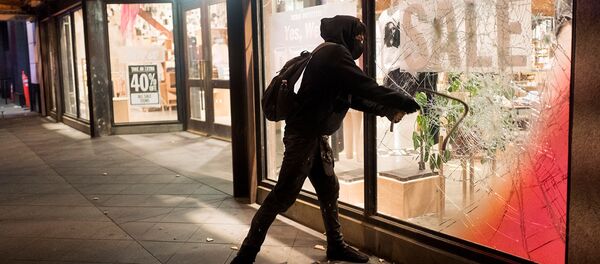 Протестующий разбивает витрину одного из предприятий во время демонстрации в связи со смертью Джорджа Флойда, убитого полицейским в Миннеаполисе (29 мая 2020). Лос-Анджелес - Sputnik Армения