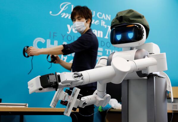 Генеральный директор Mira Robotics Кен Мацуи управляет роботом-аватаром Уго во время демонстрации в лаборатории компании в Кавасаки, Япония - Sputnik Армения