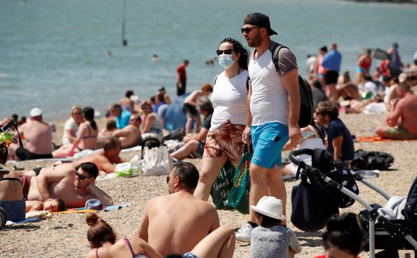 Пара в защитных масках на пляже в Саутенд-он-Си, Великобритания - Sputnik Армения