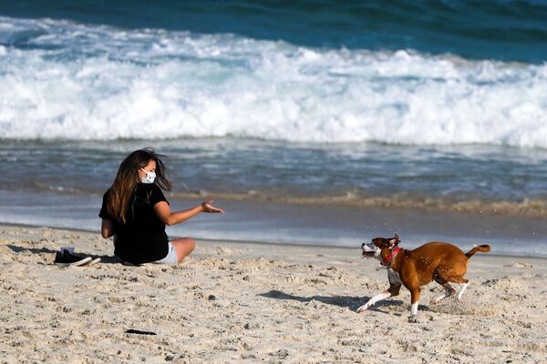Девушка во время игры с собакой на пляже в Рио-де-Жанейро, Бразилия - Sputnik Армения