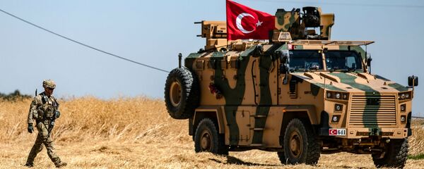 Американский солдат идет рядом с турецкой военной машиной во время совместного патрулирования с Турцией в сирийской деревне Аль-Хашиша на окраине города Таль-Абьяд вдоль границы с Турцией (8 сентября 2019). Сирия - Sputnik Արմենիա