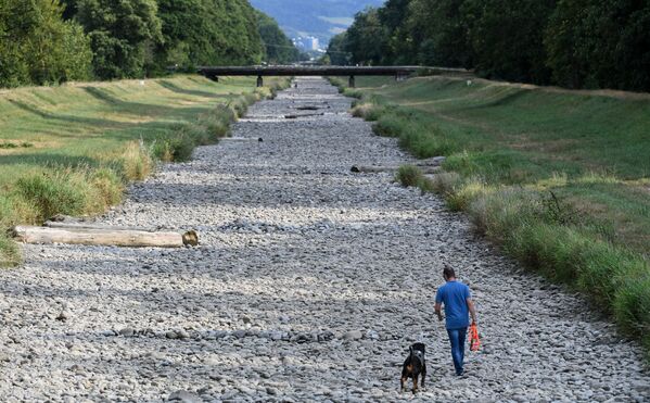 Человек гуляет со своей собакой по пересохшему руслу реки Драйзам - Sputnik Армения