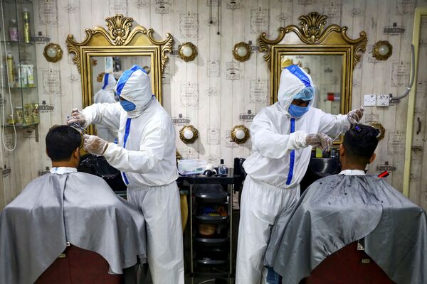 Барберы в защитных костюмах работают в одной из парикмахерских салонов Дакки - Sputnik Армения