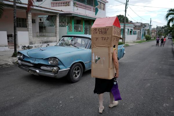 Женщина в картонной конструкции для защиты от коронавируса на улице в Гаване - Sputnik Армения