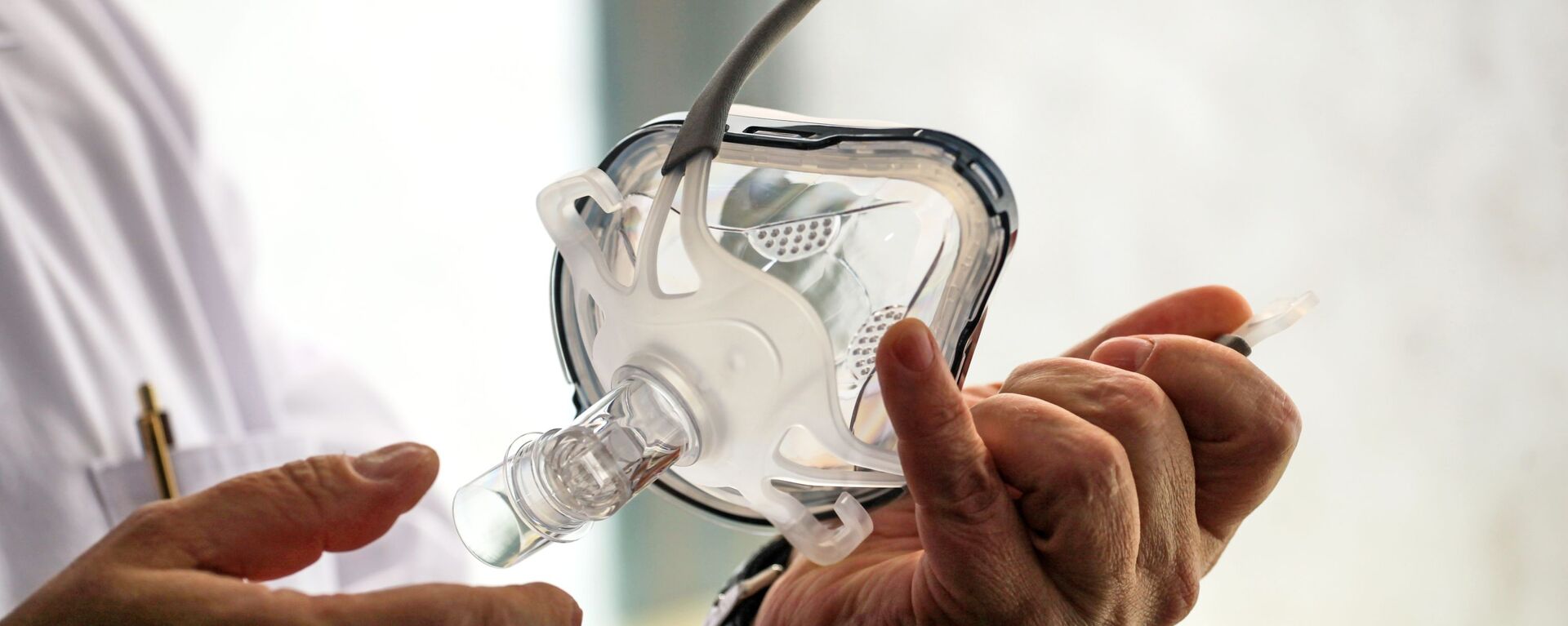 Врач держит в руках маску для искусственной вентиляции легких в палате госпиталя ветеранов войн в Иркутске - Sputnik Армения, 1920, 23.03.2021