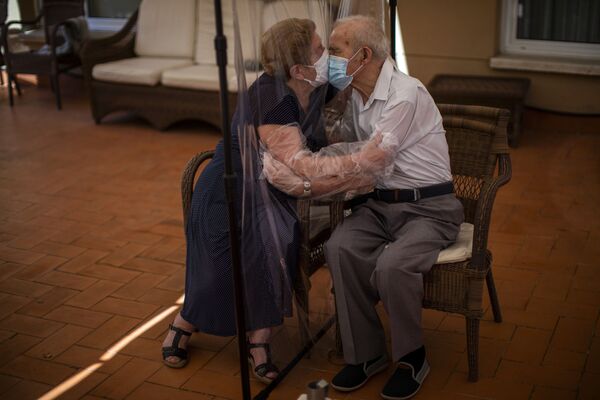 Агустина Канамеро, 81 год, и Паскуаль Перес, 84 года, обнимаются через экран в доме престарелых в Барселоне, Испания - Sputnik Армения