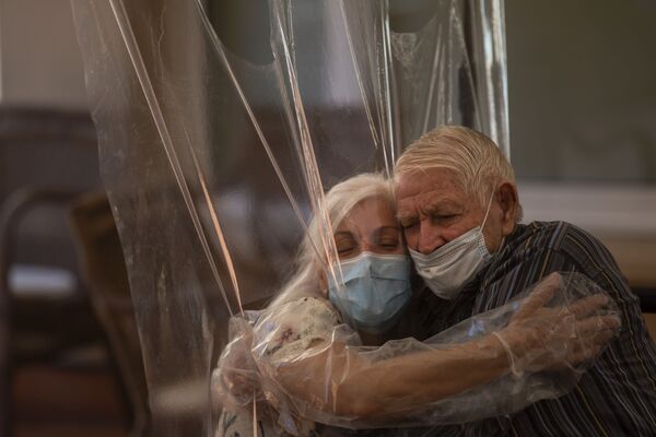 61-летняя Долорес Рейес Фернандес обнимает своего отца Хосе Рейеса Лозано, впервые за 4 месяца, в доме престарелых в Барселоне, Испания - Sputnik Армения