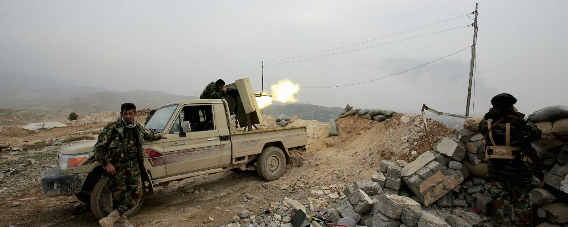 Курдский боец пешмерга стреляет из оружия по позициям группировки Исламского государства неподалеку от города Синджар (29 января 2015). Ирак - Sputnik Армения, 1920, 22.02.2021