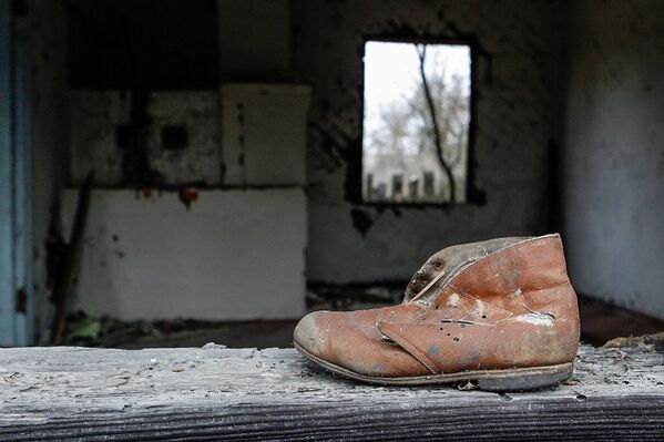 Детский ботинок на подоконнике дома деревни Ломачи, отселенной в 1990-1991 годах. - Sputnik Армения