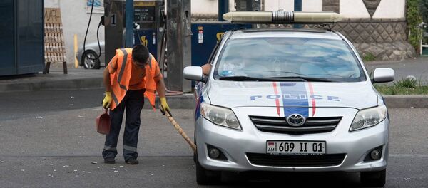 Дворник убирает возле полицейской машины Дворник убирает возле полицейской машины - Sputnik Армения