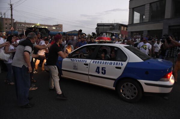 Демонстранты препятствуют проезду полицейской машины. - Sputnik Армения