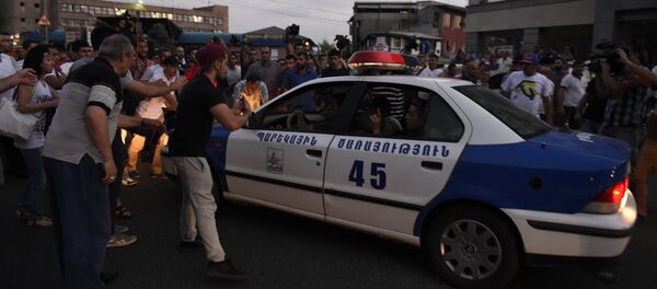 Демонстранты препятствуют проезду полицейской машины Демонстранты препятствуют проезду полицейской машины - Sputnik Армения