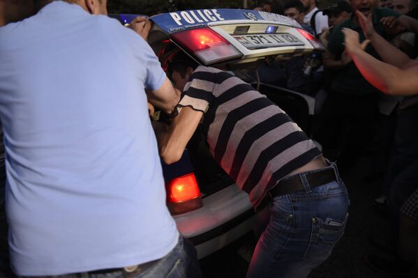 Демонстранты остановили и осматривают полицейскую машину. - Sputnik Армения