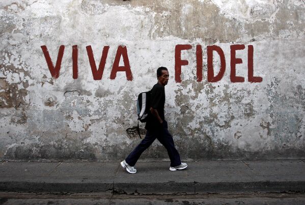 Мужчина проходит по улице на Кубе. На стене надпись Слава Кастро, 2008г. - Sputnik Армения