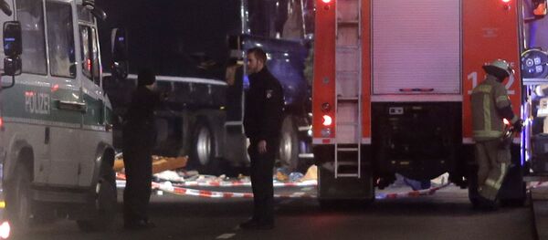 Полицейские стоят неподалеку от места, где грузовик врезался в людей, находившихся на рождественской ярмарке в Берлине Полицейские стоят неподалеку от места, где грузовик врезался в людей, находившихся на рождественской ярмарке в Берлине - Sputnik Армения