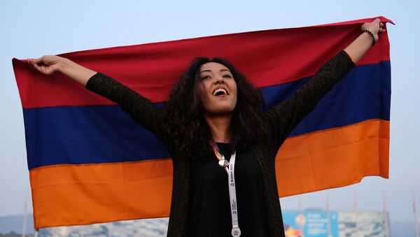 Участница XIX Всемирного фестиваля молодежи и студентов с флагом Армении во время шоу Россия в Сочи. - Sputnik Армения