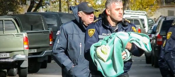 Спецназовец выносит ребенка из зоны спецоперации в Тбилиси Спецназовец выносит ребенка из зоны спецоперации в Тбилиси - Sputnik Արմենիա
