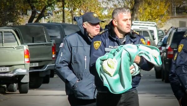 Спецназовец выносит ребенка из зоны спецоперации в Тбилиси - Sputnik Армения