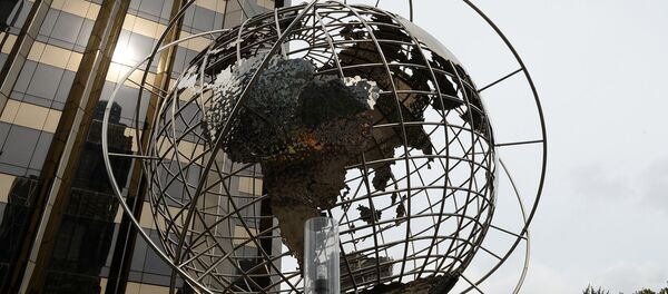 Скульптура глобуса на площади Коламбус-серкл в Нью-Йорке. На дальнем плане - международная гостиница и башня Трампа. - Sputnik Армения